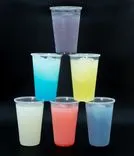 Five colorful frozen drinks in clear plastic cups stacked in a pyramid formation on a black background.
