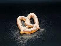 Sugar-dusted pretzel on a black background.