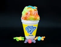 Colorful shaved ice in a branded cup with candy toppings on a black background.