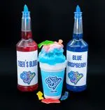 A colorful display of a shaved ice dessert with blue and red syrup, labeled 'Tiger's Blood' and 'Blue Raspberry', alongside two syrup bottles with the Sno Biz logo, on a black background.