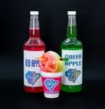 Two bottles labeled "Red Apple" and "Green Apple" next to a cup of shaved ice with red and green syrup, and "Sno Biz" branding on a black background.