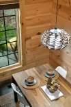 Cozy wooden cabin dining area with a window view, modern pendant light, and a set table for two.