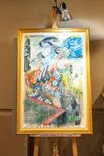 Framed painting on an easel featuring abstract figures and vibrant colors.